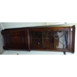 A modern mahogany finished corner cabinet with a glazed door, over a panelled door,