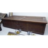 A 1930s stained oak under-bed storage box, enclosed by a panelled, hinged lid,