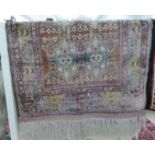 A Persian part silk/part woollen rug with two columns of three guls on a mauve ground 35'' x 53''