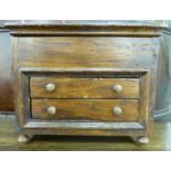 An 'antique' inspired rustically constructed miniature chest with straight sides and a hinged lid,