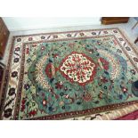 A Persian carpet with dense floral decoration and repeating gul multi-guard border on a green and