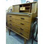 A 1970s teak bureau with a horizontally sliding tambour front, over a slide and four drawers,