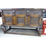 A mid 20thC Jacobean inspired carved oak dresser base, comprising three in-line drawers,