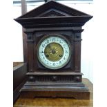 An early 20thC German carved oak cased mantel clock with a pointed arched top and straight sides,