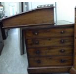 A mid Victorian mahogany Davenport with an angled scribe on the sliding box top,