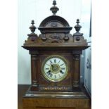 An early 20thC American walnut cased mantel clock; the bell and gong movement faced by a Roman dial,