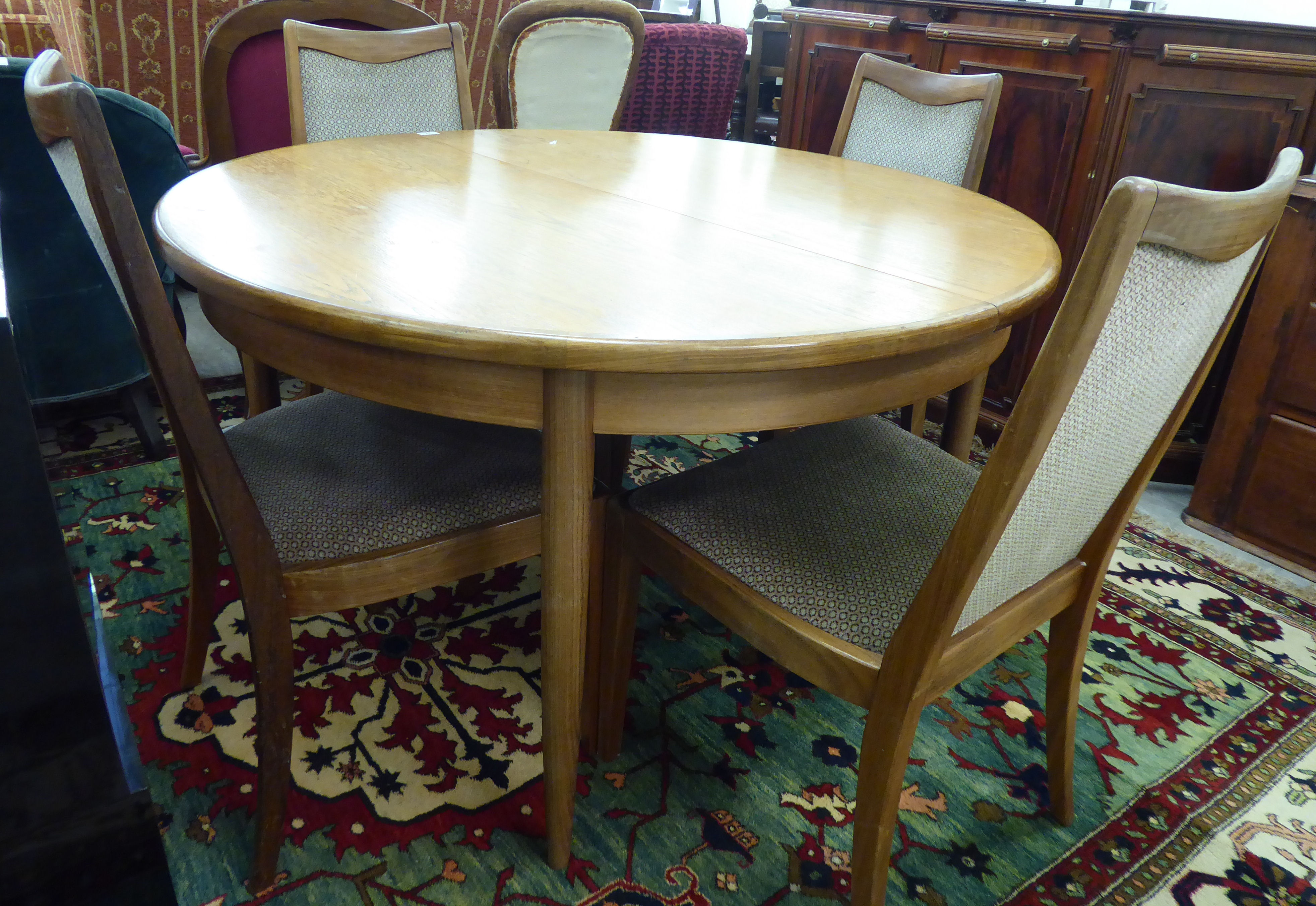 A modern G-Plan teak dining table, the two part D-end top incorporating a concealed folding leaf,