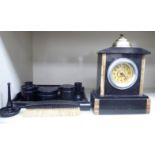 A late Victorian black slate and brass mounted mantel timepiece with a domed top;