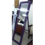 A modern dressing room mirror with a bevelled plate and conforming lilac coloured glass border