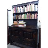 A mid 20thC stained oak cottage dresser with a planked, open shelved superstructure,