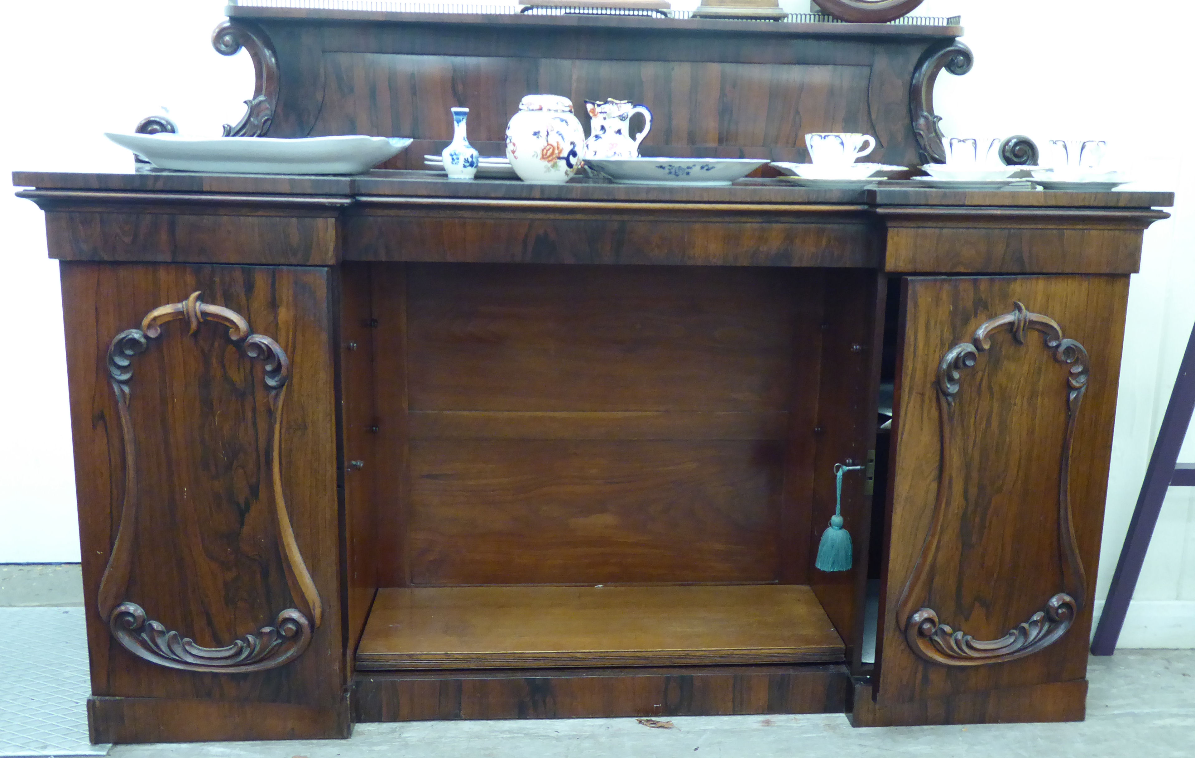 A William IV rosewood chiffonier with a panelled upstand and brass gallery,