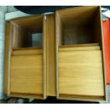 A pair of modern teak floorstanding cabinets, each enclosed by a pair of horizontally sliding doors,