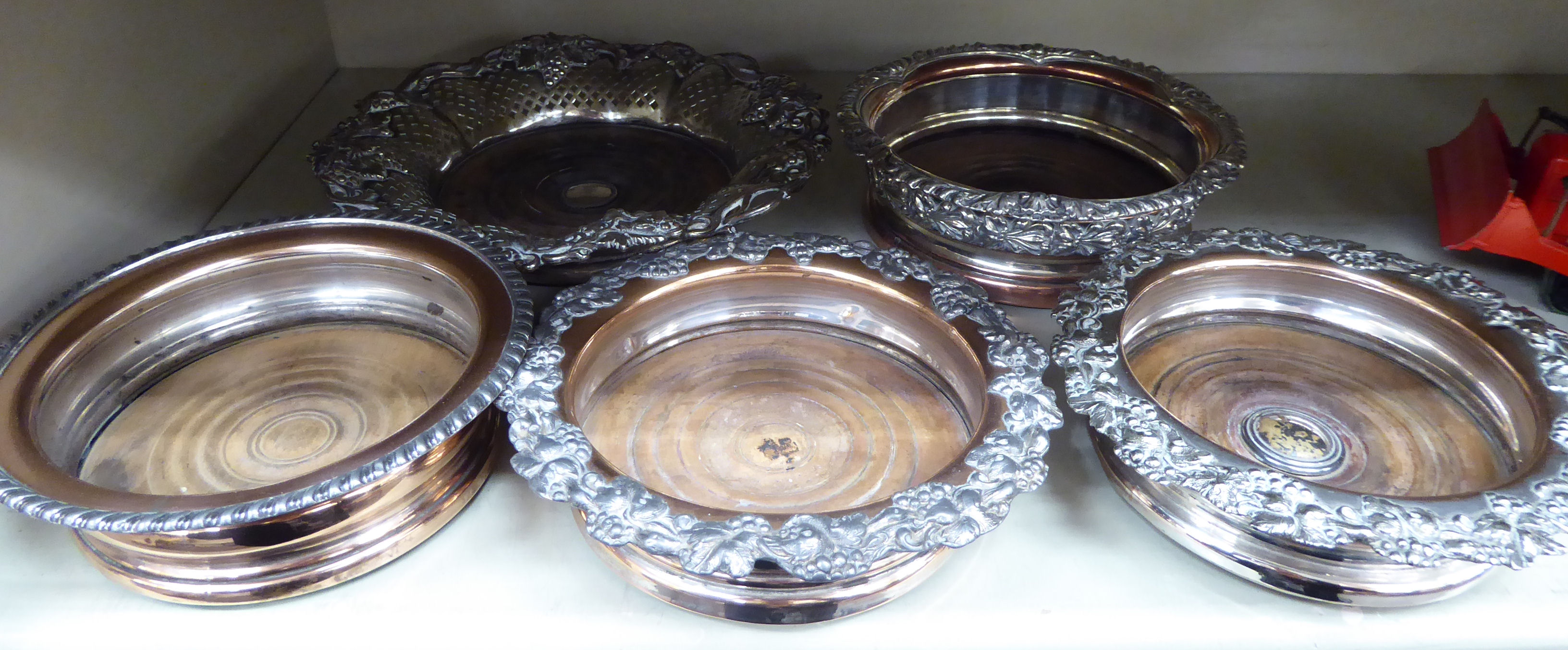 A pair and three individual mid 19thC silver plated wine coasters with turned wooden bases largest