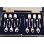 A set of twelve George V silver teaspoons and a pair of sugar tongs by Josiah Williams & Co.