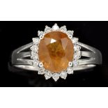 An orange sapphire and diamond cluster ring, the oval facet cut sapphire weighing approximately 3.