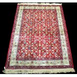 A woven Kashmir rug, with full floral design on claret ground, 175 x 117cms.