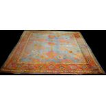 An antique Ushak carpet, decorated with bold floral medallions on blue ground, 355 x 368cms.