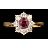 A ruby and diamond cluster ring, the central oval facet cut ruby measuring 5.3 x 4.