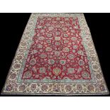 A Tabriz carpet, the claret ground with full floral scrolling decoration, 326 x 214cms.