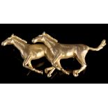 A 9ct. yellow gold brooch of two galloping horses, 5.5cms wide, 19.7grms gross.