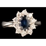 A sapphire and diamond cluster ring, the oval facet cut sapphire measuring 7.5 x 5.1 x 2.