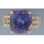 A tanzanite and diamond ring, the slightly oval facet cut tanzanite measuring 11.4 x 10.9 x 7.