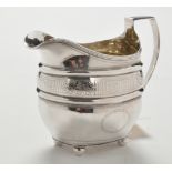 A George III silver cream jug, by Duncan Urquhart & Naphtali Hart, London 1806, of helmet form,