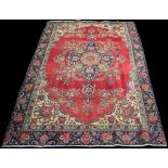 A Tabriz style carpet, the central floral medallion on claret ground, 283 x 187cms.