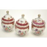 Set of three Famille Rose jars with domed covers, with dentil edges, the covers with upturned rims,