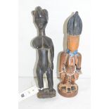 A Yoruba Ibeji carved wooden female figure; another.