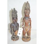 Yoruba carved wooden Ibeji figures, one female; one male with beaded necklaces and scarification.