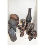 West African carved wooden busts depicting tribal men and women; a clay bust of a tribal woman,