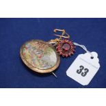 A yellow metal brooch with embroidered landscape within leaf pattern border;