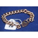 A 9ct. yellow gold curb link bracelet with heart shaped clasp, 21.8grms.