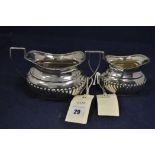 A silver two handled sugar bowl and cream jug, half gadrooned, near matching, 7.6oz. gross.