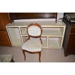 A modern cream painted sideboard unit with open shelves and gold painted borders,