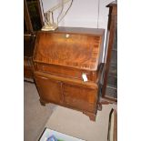 A mahogany bowfront bureau with frieze drawer and cupboards below, 76cms wide.