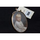 A miniature photographic portrait of a child, in gold-coloured metal pendant frame.