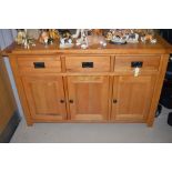 A modern oak sideboard, fitted three drawers to frieze and cupboards below, 140cms.