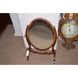 An oval plate mahogany swing toilet mirror.