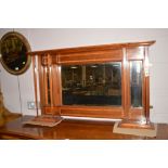 A mahogany satinwood bounded over mantel mirror with three bevel plates, 120cms wide.