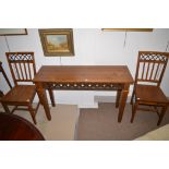 A stained pine console table; together with a pair of matching chairs, console 122cms wide.