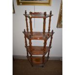 A late 19th/early 20th Century walnut four tier whatnot, 134cms high.