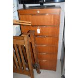 A teak six drawer upright chest of drawers, 60cms wide.