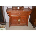 A Chinese hardwood altar-style table cabinet, with brass lock plate carved with "Mon", 25cms wide.