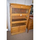 A four tier light oak Globe Wernike style stacking bookcase,