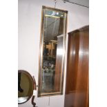 A rectangular bevelled wall mirror in modern gold and black frame.