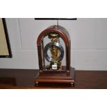 A modern mahogany and brass dome shaped glazed mantle clock with visible movement, 29cms high.