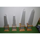 Two pairs of wooden obelisks, 46cms and 36cms high.