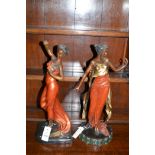 Cast metal figurines depicting ladies.